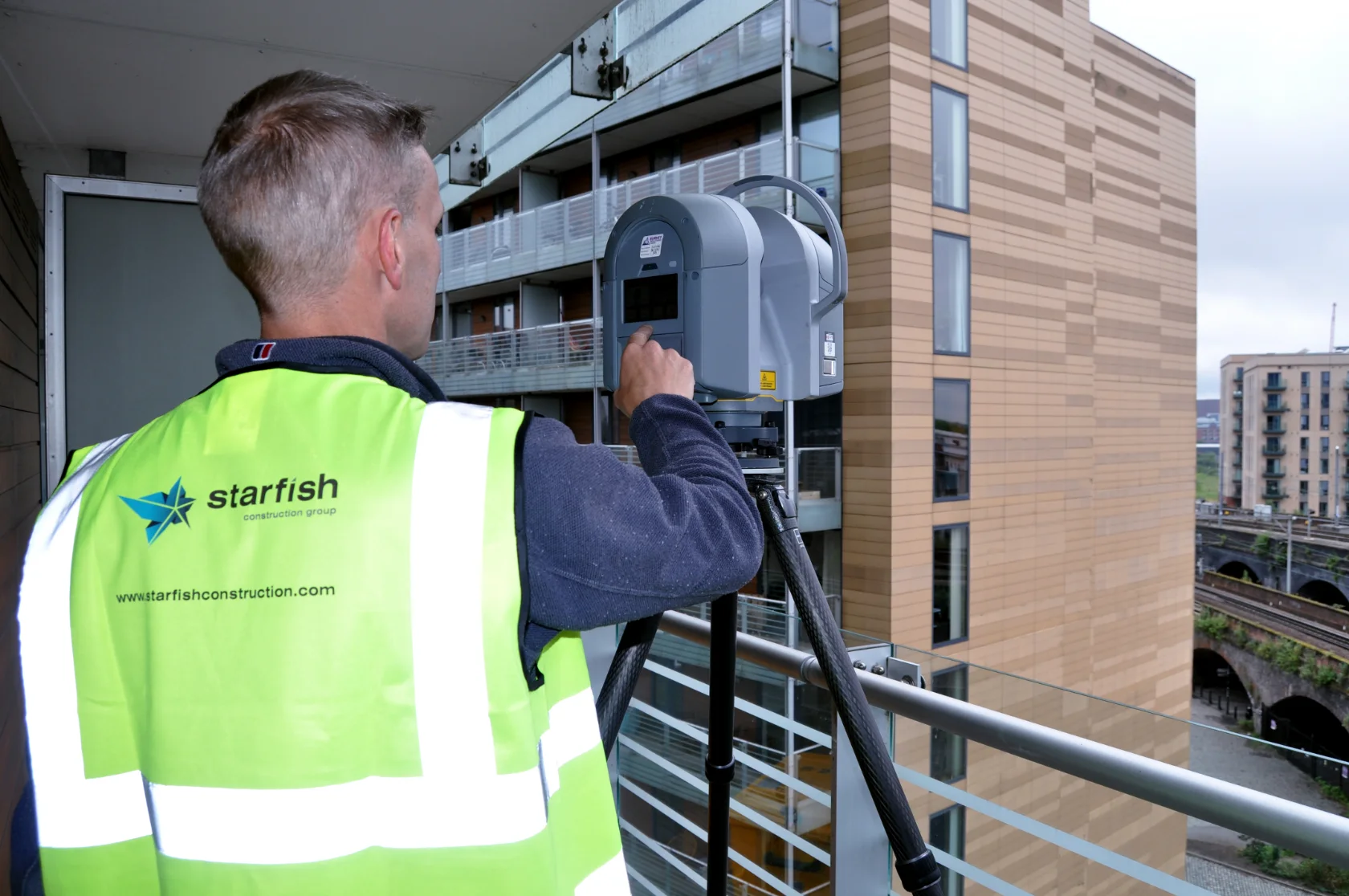 Starfish Construction surveyor using a 3D laser scanner on a residential balcony
