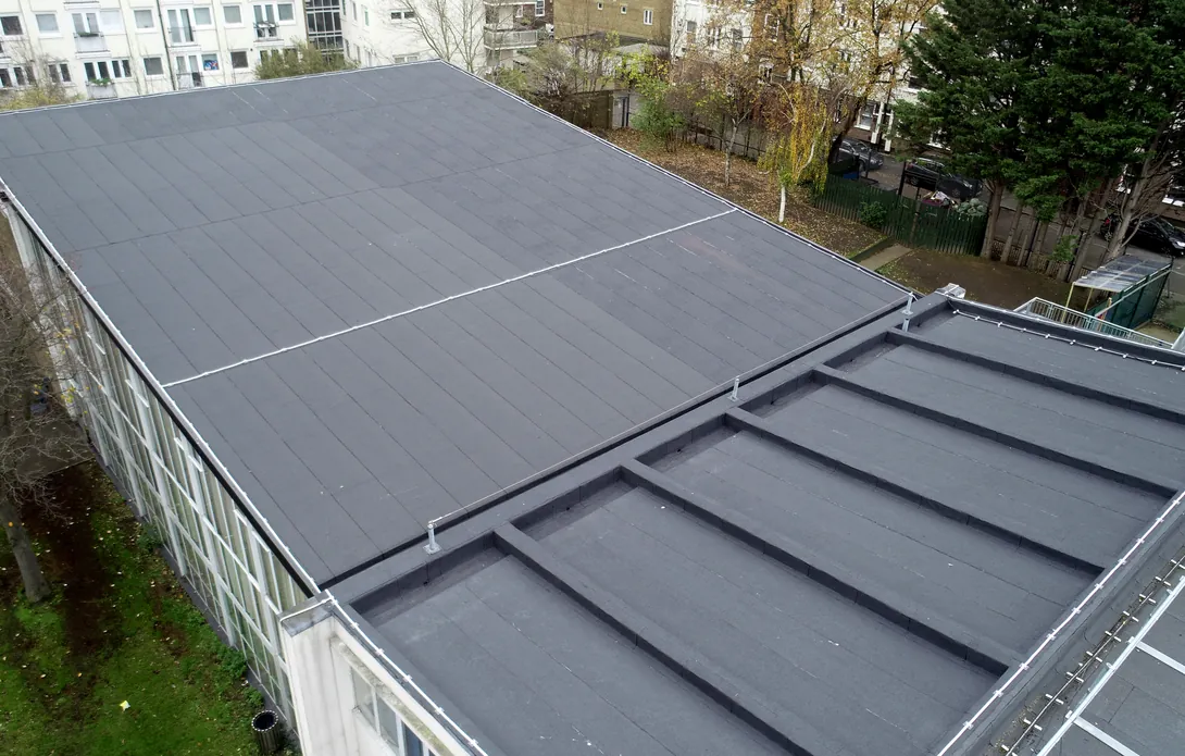 Angled drone view of the new built-up felt roof overlay on the assembly hall