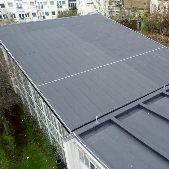 Angled drone view of the new felt roof overlay on the assembly hall at an academy school in London