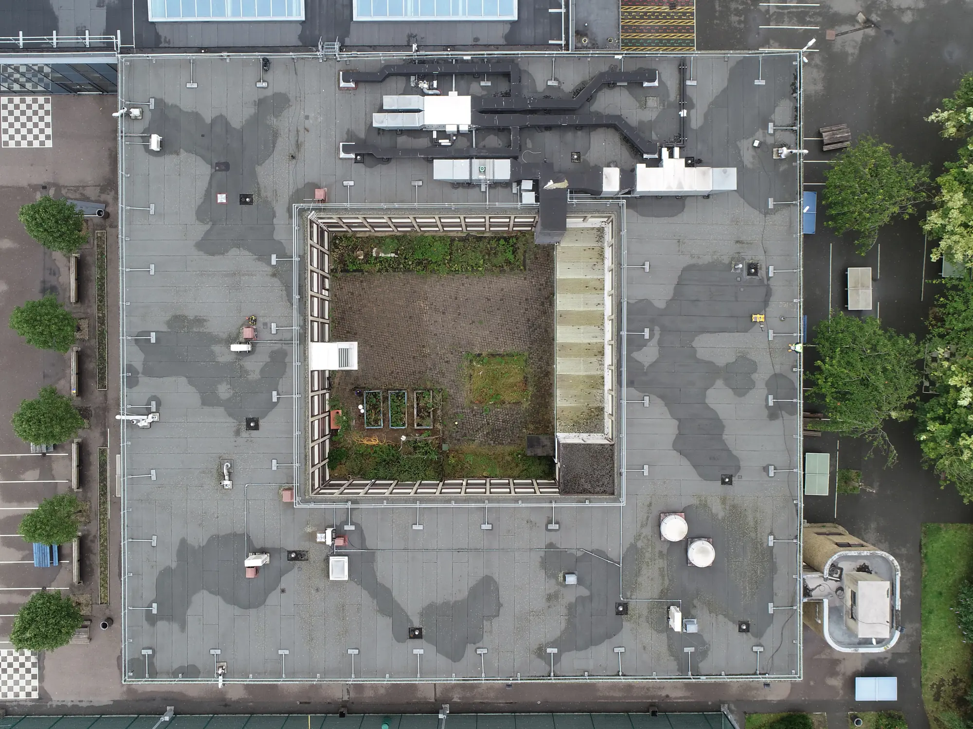 Drone view of the courtyard roof before refurbishment, with patchy weathered areas visible