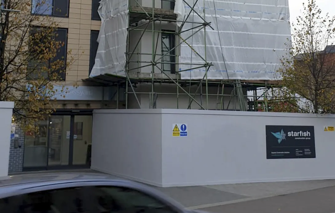 Hoarded entrance area with scaffold and protective sheeting at Glassyard