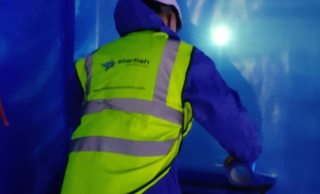 SEAS operative working inside an asbestos removal enclosure