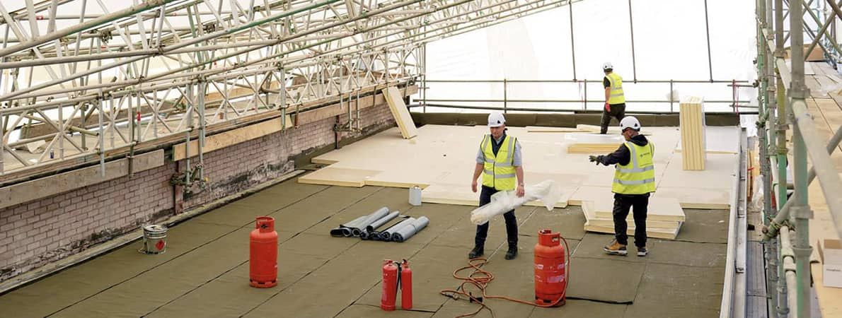 work people flooring an indoor space