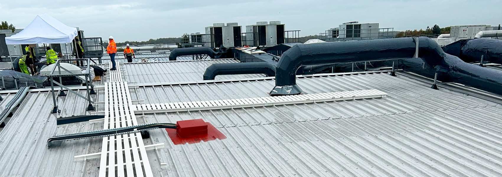 Scaffolding within enclosed work area with work people laying flooring