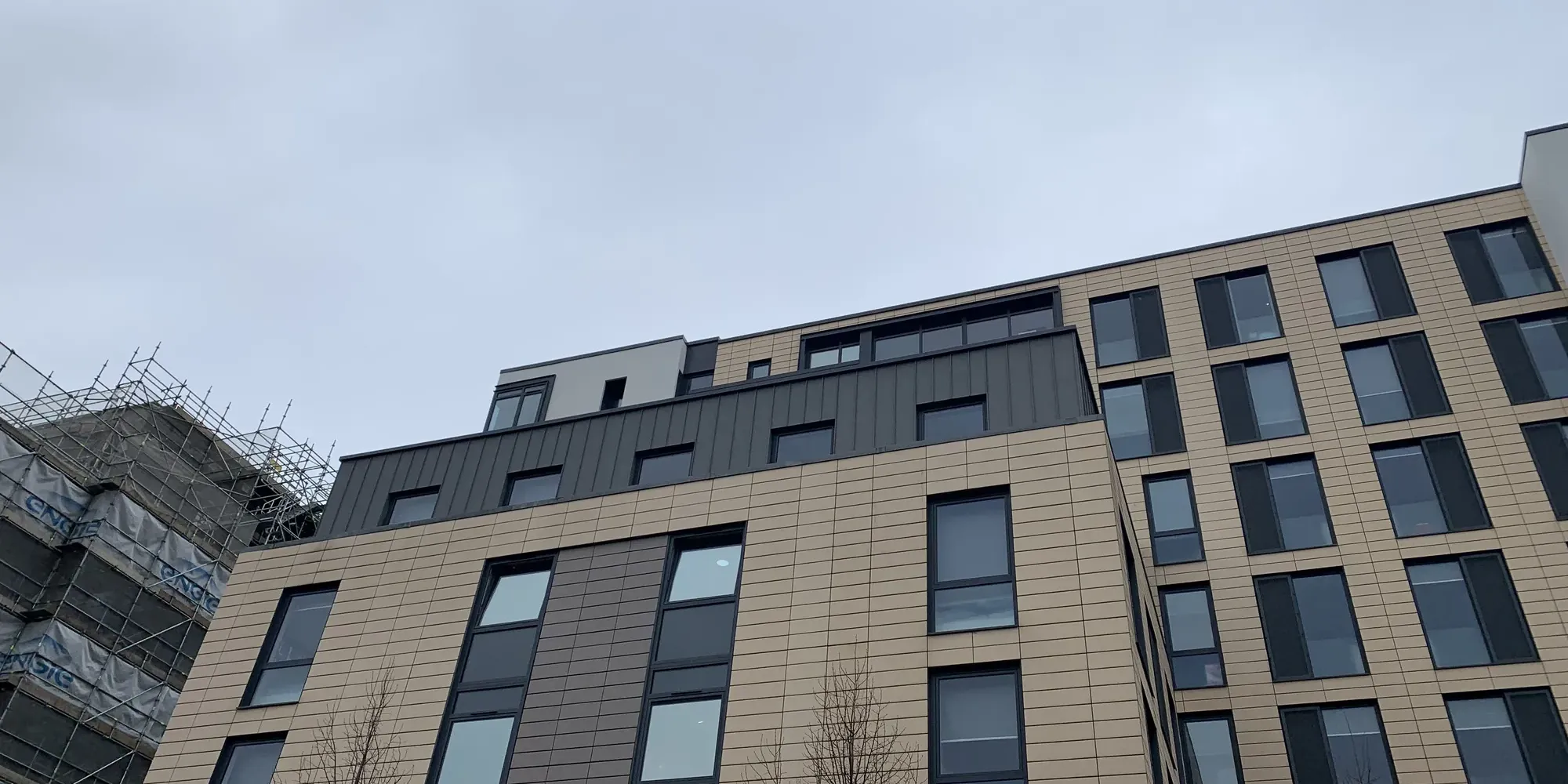 Wide view of the remediated Glassyard façade with new render and zinc panels