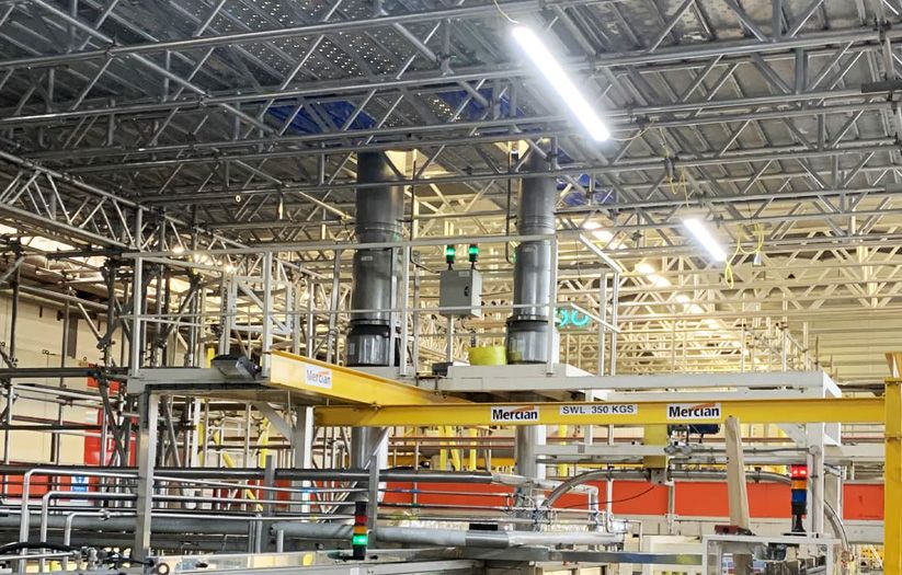building showing scaffolding and green netting surrounded by trees