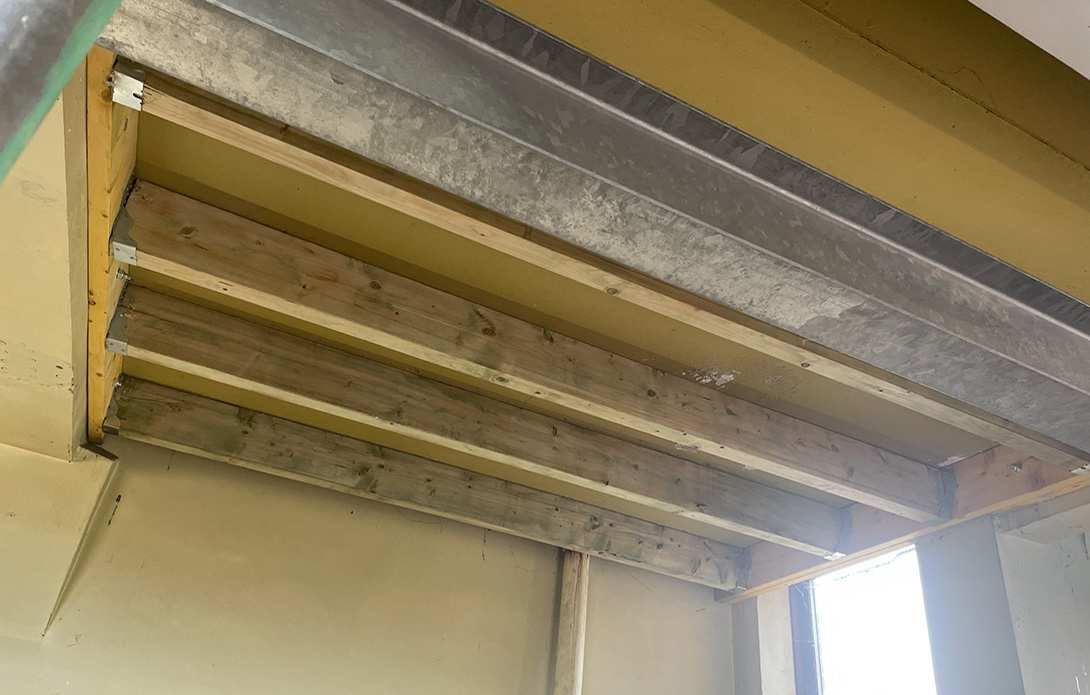 Crane positioning steel onto a industrial roof