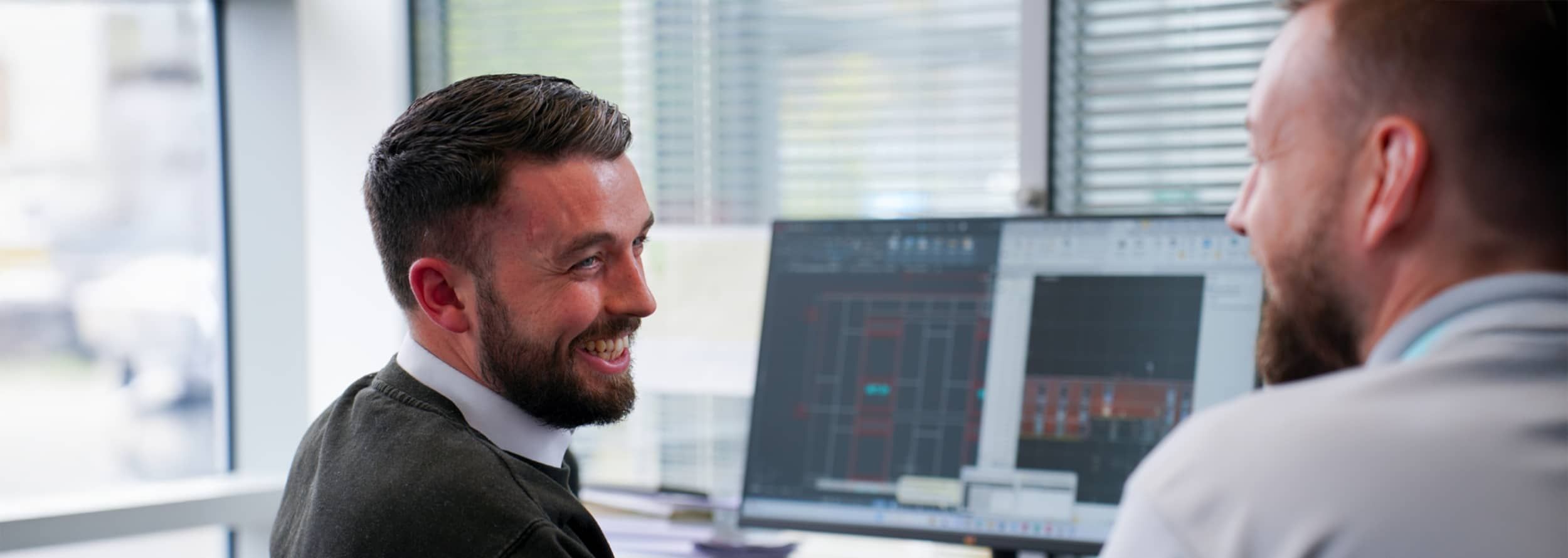 Starfish surveyors discussing plans in front of a computer screen
