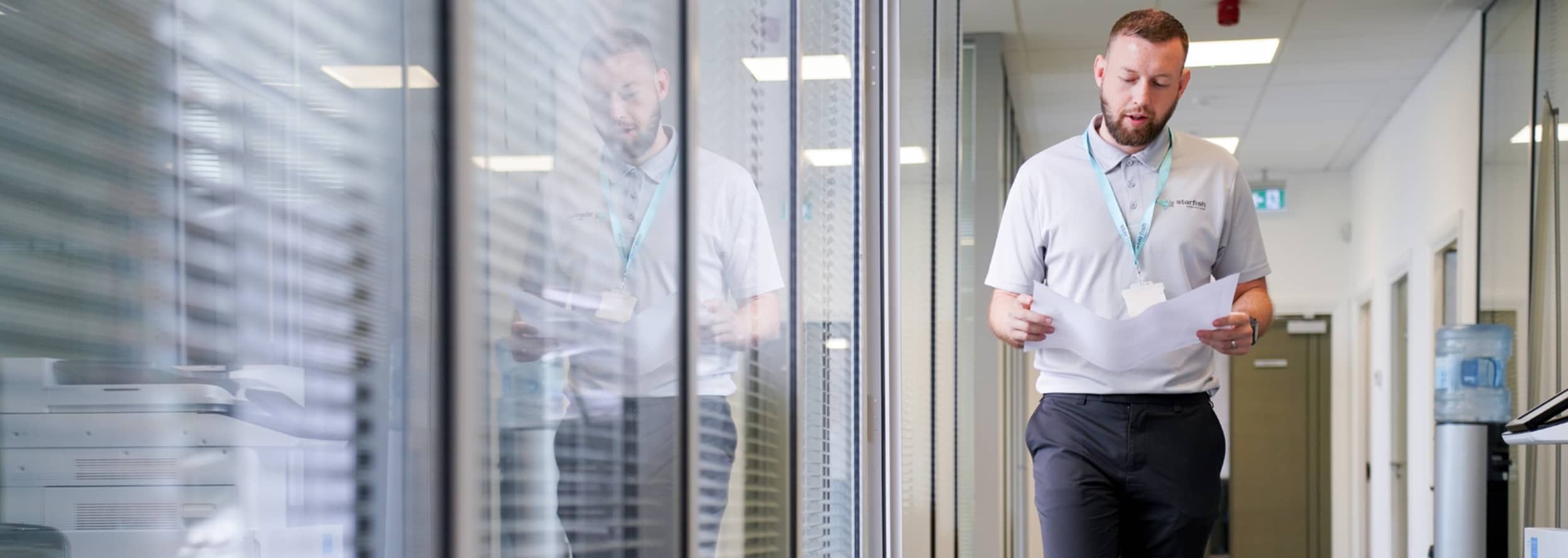 Starfish staff member walking through the office reviewing drawings